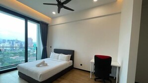 Een moderne hotelkamer met een groot bed, een bureau en uitzicht op de stad.