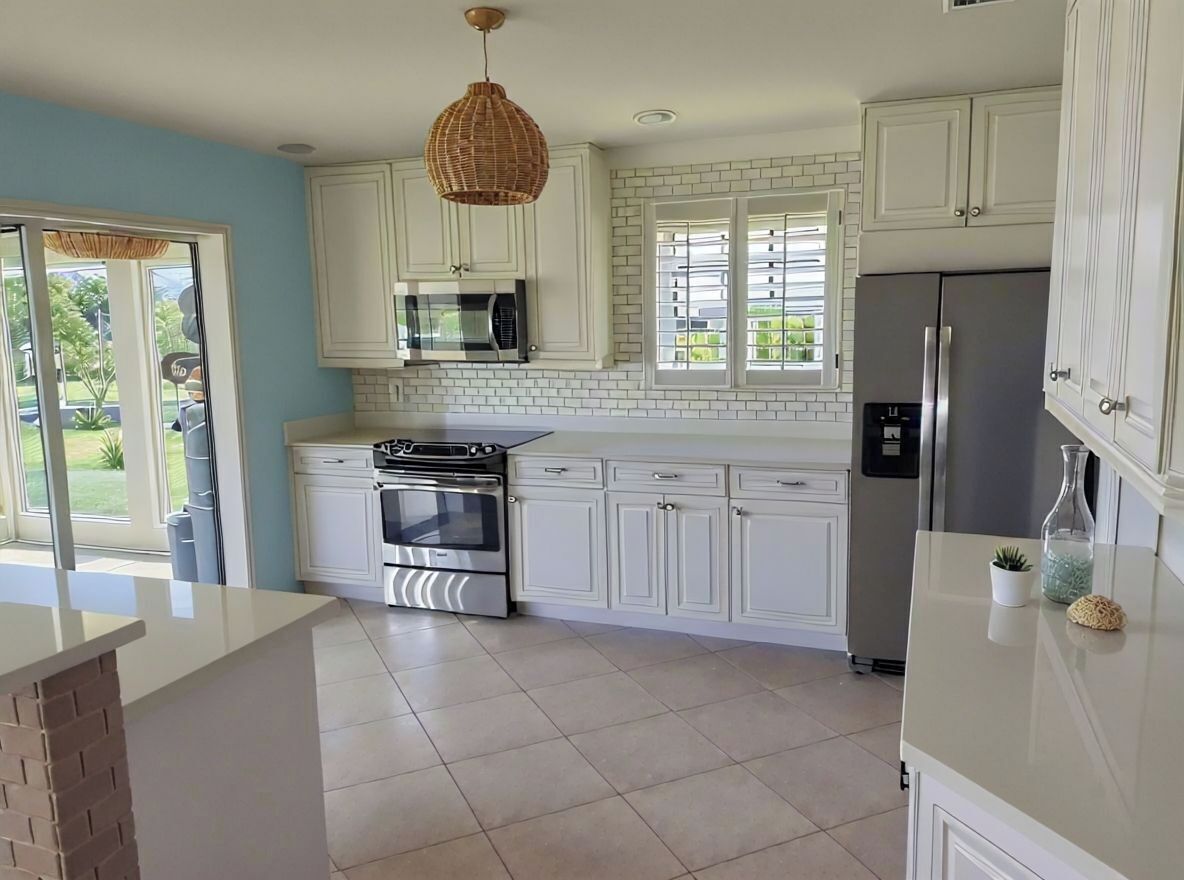 A modern kitchen with white cabinets, a stainless steel refrigerator, a microwave, and a stove.
