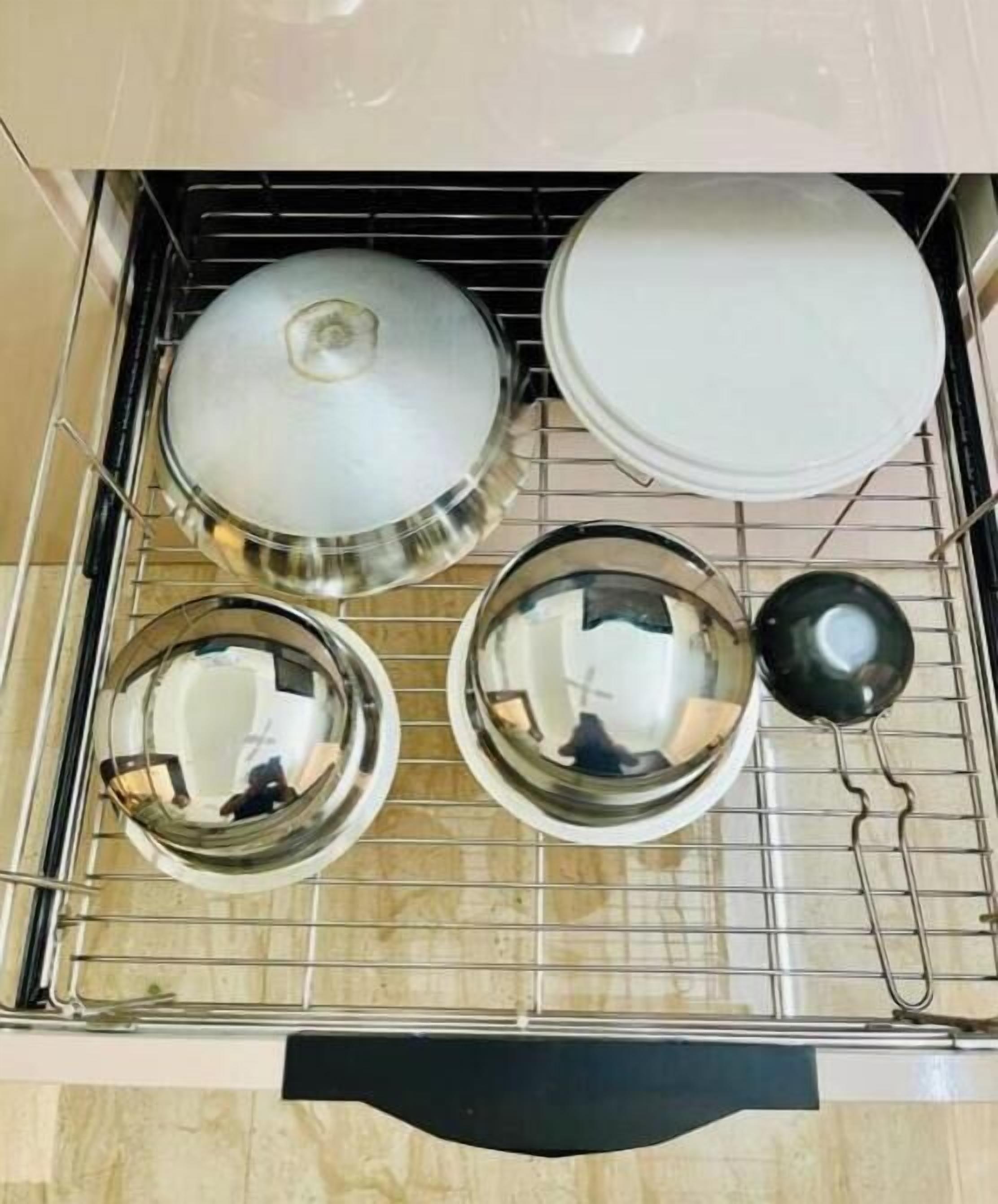 Eine Küche mit vier Edelstahl-Kochtöpfen und -pfannen an einem Gestell.