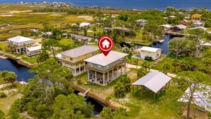 An aerial view of a coastal residential area with houses, a dock, and a river. - Cedar Island Coastal Retreat | Gulf Access, Huge Deck & Fami (Taylor County)