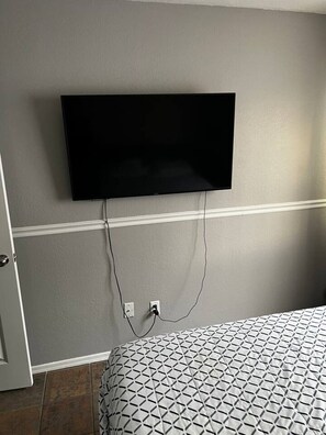 Escritorio, tabla de planchar con plancha, wifi y ropa de cama