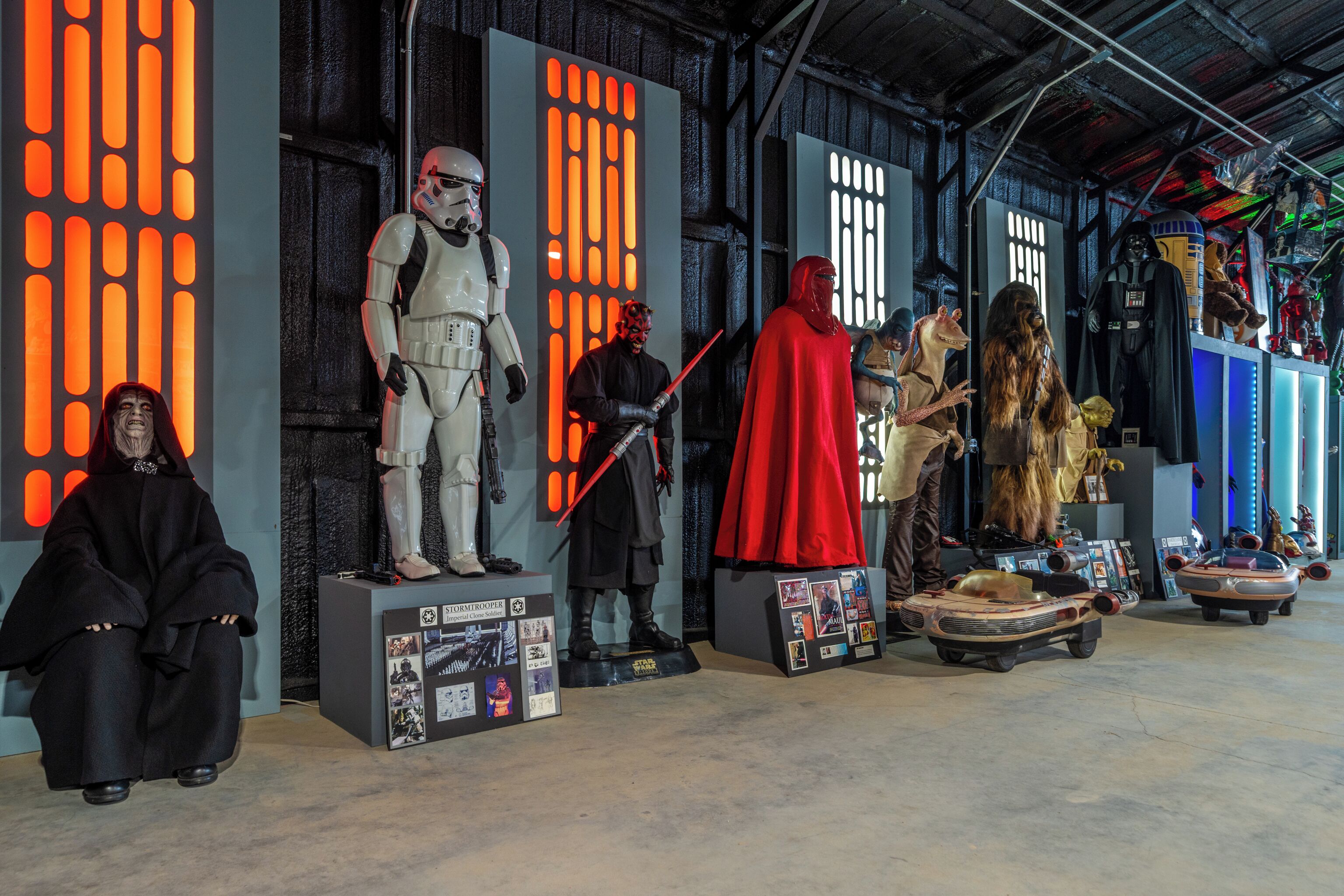 A display of Star Wars characters and vehicles in a museum setting.