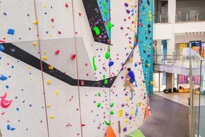 Una pared de escalada con presas de colores en un espacio interior moderno.