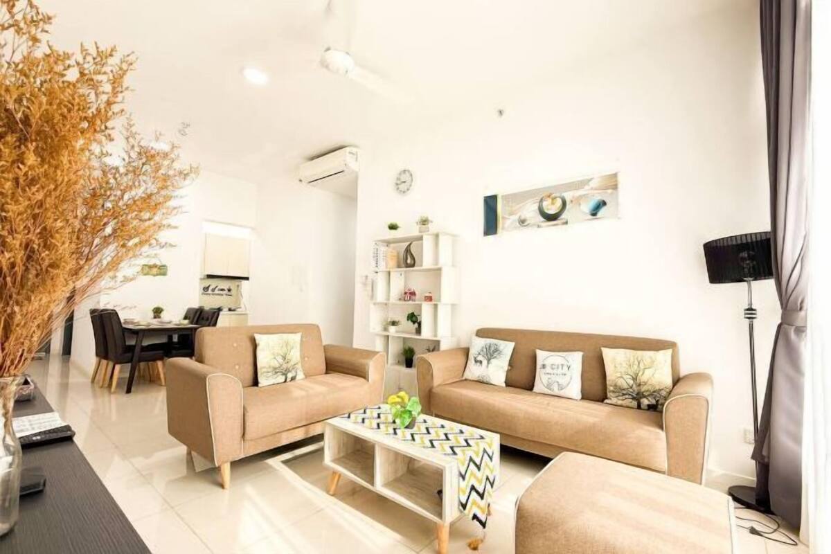 A modern living room with a sofa set, a coffee table, and a dining area in the background.