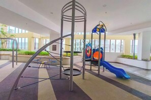 Un parque infantil interior con un tobogán y estructuras para escalar.