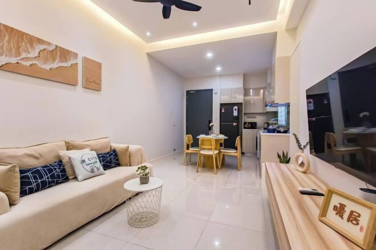 A modern living room with a sofa, coffee table, and a dining area with chairs.