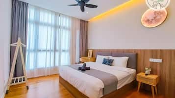 Ein modernes Schlafzimmer mit einem großen Bett, einem Deckenventilator, Holzboden und einem Nachttisch mit Lampe.