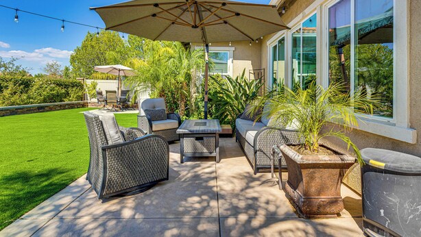 A patio with outdoor furniture, a large umbrella, and potted plants. - 10 Mi to Temecula Old Town: Pet-Friendly Home (Murrieta)