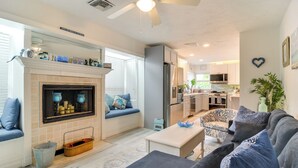 A modern living room with a fireplace, seating area, and a kitchen in the background. - Waterfront Largo Home w/ Canal Access + Boat Dock (Largo)