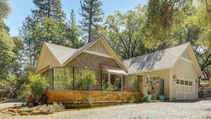 A two-story stone house with a covered porch and a garage. - All-Season Outdoor Base Camp: Gold Country Home! (Fiddletown)