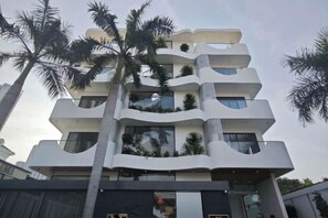 A multi-story building with balconies, palm trees, and a modern architectural design. - Panda Garden Hotel &Apartment (Ho Chi Minh City)