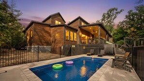 A two-story wooden house with a swimming pool, deck, and outdoor seating area. - Luxury 4BR Cabin on Pond for 18p- Pool, Sauna, Hot Tub & Game Room in Broken Bow (Broken Bow)