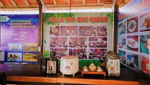 A restaurant named "Villa Tra Que Green" with a rustic wooden ceiling and a wall decorated with food images. - Tra Que Green Villa Hoi An (Hoi An)