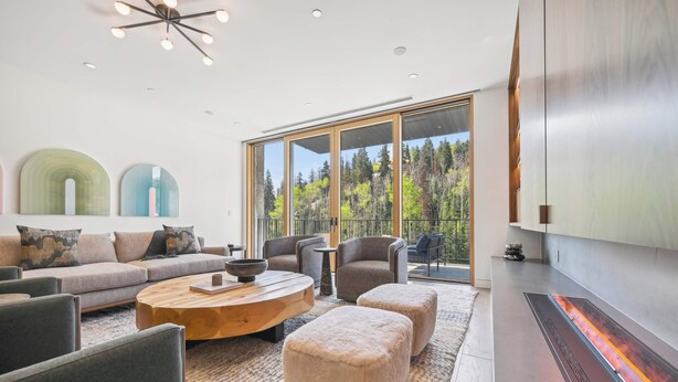 A modern living room with a sofa, chairs, a coffee table, and a fireplace.