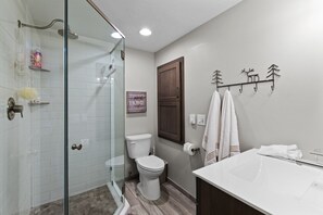 Bathroom featuring a glass walk-in shower, toilet, and vanity sink. - Lakefront Condo del Sol with Boat Slip & Pool (Sandpoint)