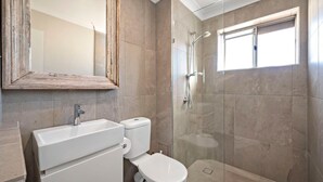 A bathroom with a shower, toilet, and sink. - Bella Vista 19 Waterfront views (Shoal Bay)