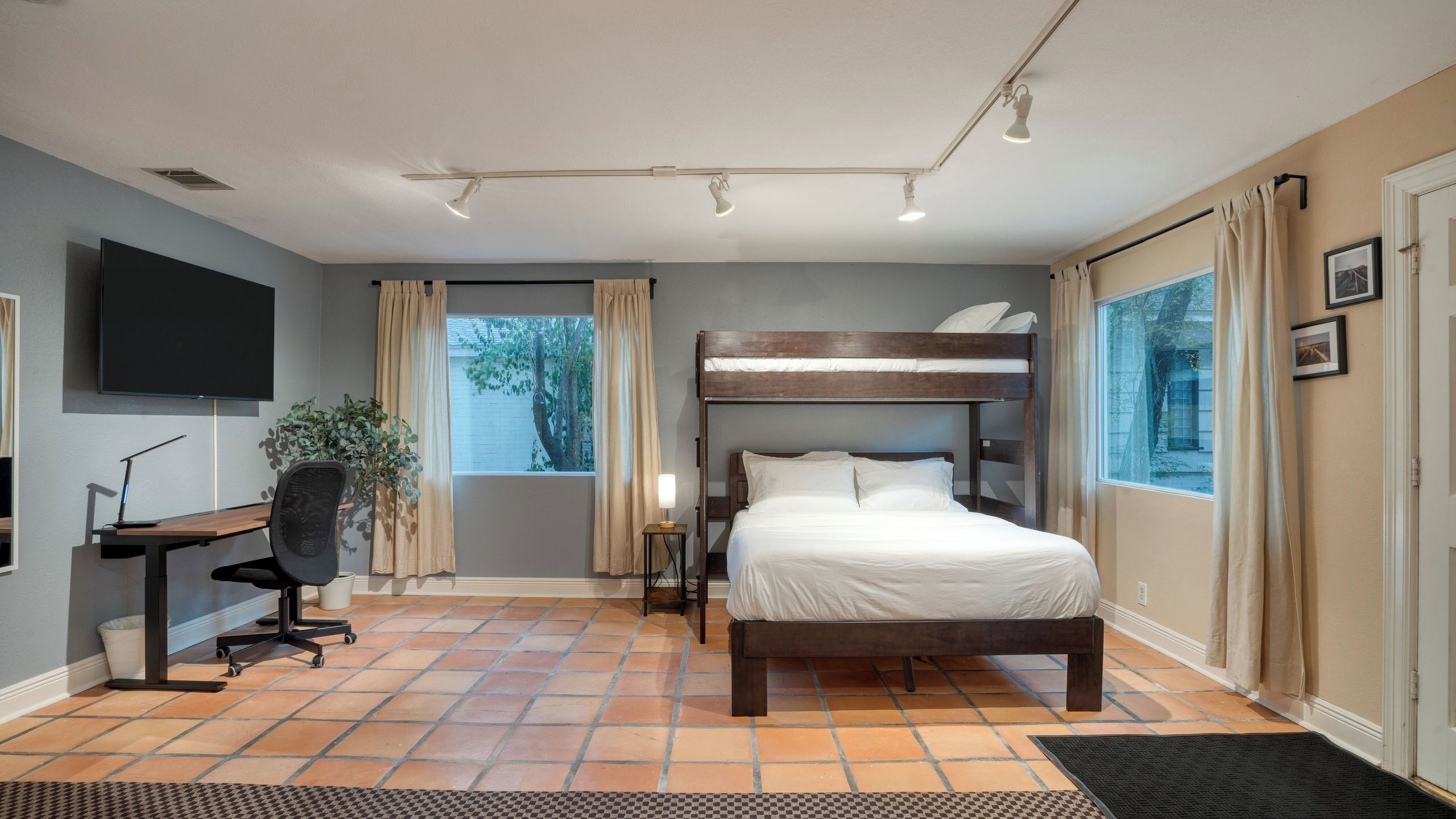 Une chambre à coucher avec un lit, un bureau, une chaise et un téléviseur.