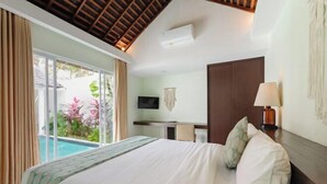 Ein Hotelzimmer mit Bett, Schreibtisch, Fernseher und Blick auf einen Swimmingpool.