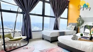 Een moderne slaapkamer met een groot bed, twee kleinere bedden, een hangstoel en uitzicht op de stad.