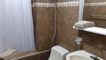 A bathroom with a shower, toilet, and sink.