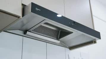 A kitchen hood with a control panel and ventilation grille.