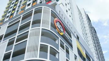 Un edificio de varios pisos con fachada curva, balcones y un logotipo circular destacado.