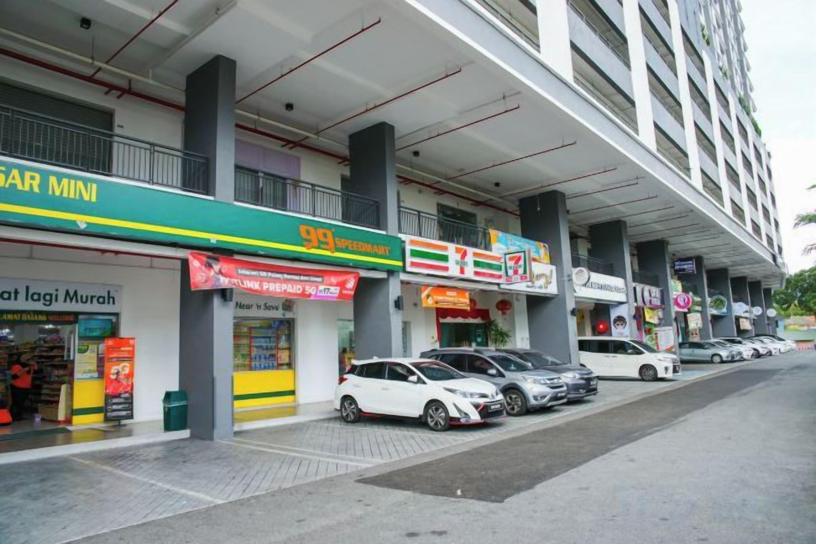 Un immeuble commercial abritant plusieurs commerces, notamment un magasin 7-Eleven et un supermarché.