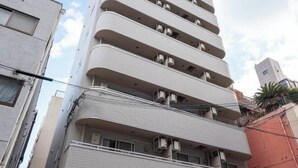 Un edificio de varios pisos con balcones y unidades de aire acondicionado.