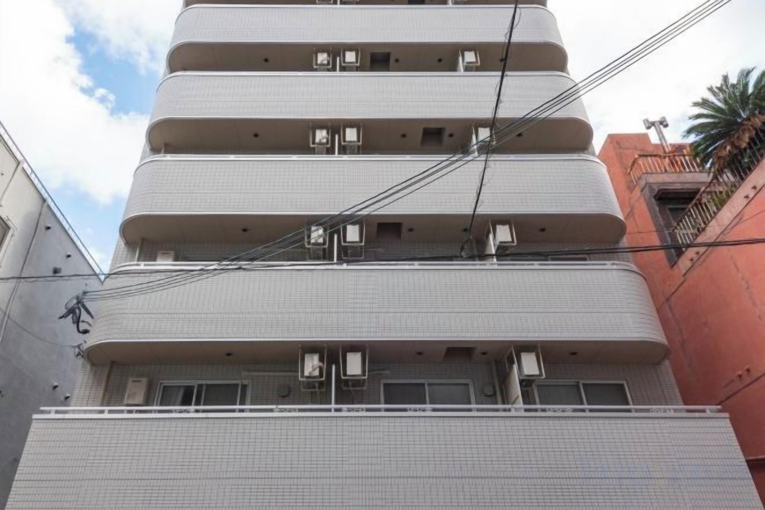 A multi-story building with balconies and air conditioning units.