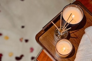 A wooden tray with two candles and a glass container with a candle. - The Palm Suite at Lava Mansion (George Town)