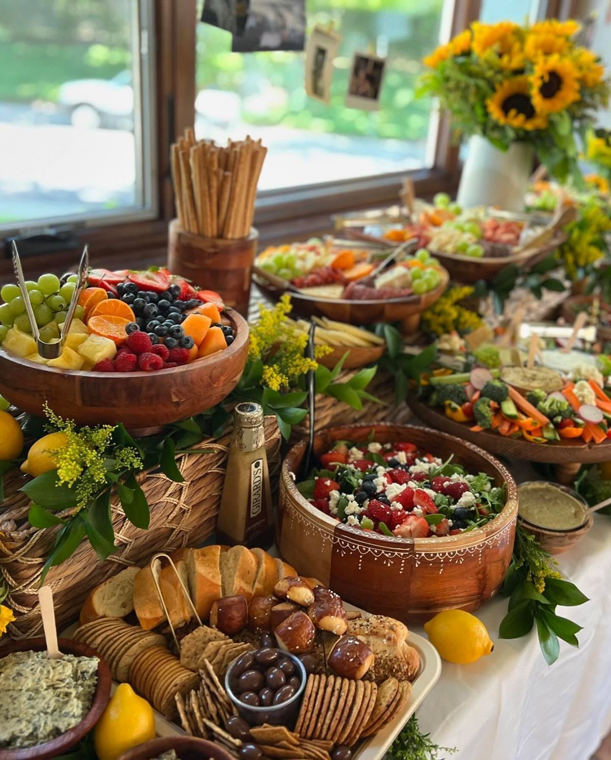 Ein reichhaltiges Buffet mit verschiedenen Speisen, darunter Obst, Käse und Brot.