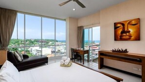 Een hotelkamer met een groot bed, een bureau en uitzicht op de stad.