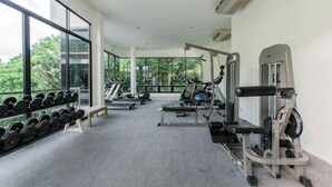 Un gimnasio con cintas de correr, máquinas de pesas y mancuernas.