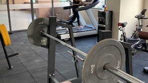 A gym with a treadmill, weight bench, and a stationary bike. - By Trixia BE Apartments, Luxury Studio Apartments near IT Park (Cebu City)