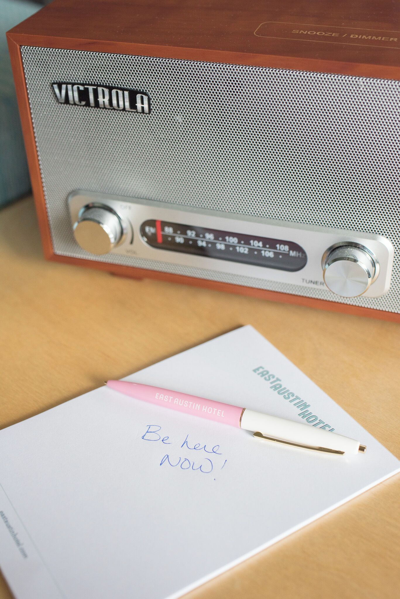 Ein altes VICTROLA-Radio, ein rosa Stift und ein handschriftlicher Zettel auf weißem Papier.
