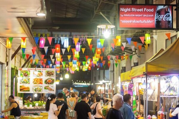 A bustling night market with food stalls and a Coca-Cola sign. - Hometel Night Bazaar Chiangmai (Chiang Mai)