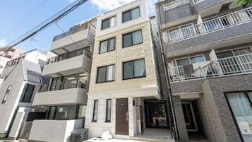 A multi-story residential building with a central entrance, balconies, and a modern architectural design.