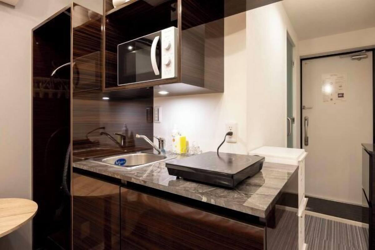 A modern kitchen with a built-in microwave, a sink, and a countertop.