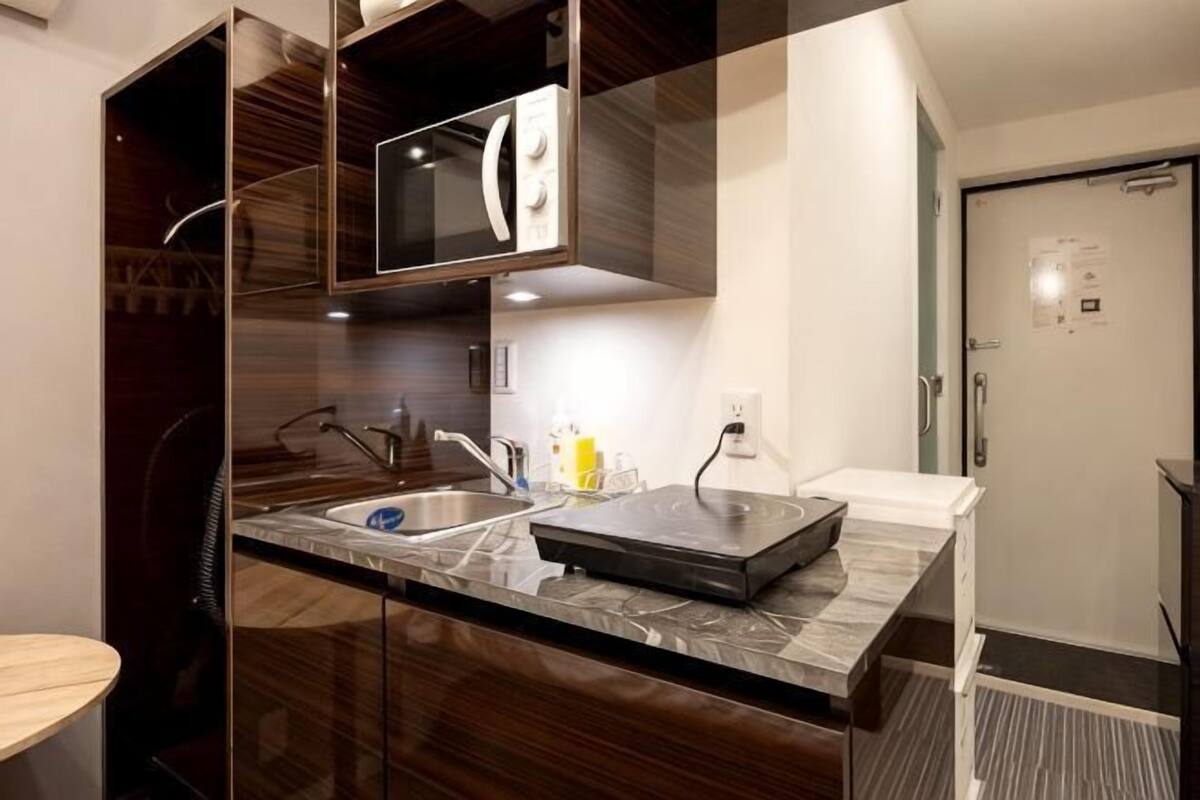 A modern kitchen with a double sink, a microwave, and a built-in oven.