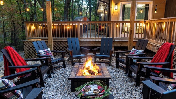 A deck with outdoor seating, a fire pit, and string lights. - Lodge-style Home Near Gatlinburg w/ Theater, Hot Tub & Game Room Evergreen Escape by Avantstay (Gatlinburg)