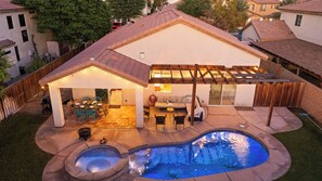 Un jardin avec une piscine, un espace détente sur la terrasse et un coin extérieur abrité.