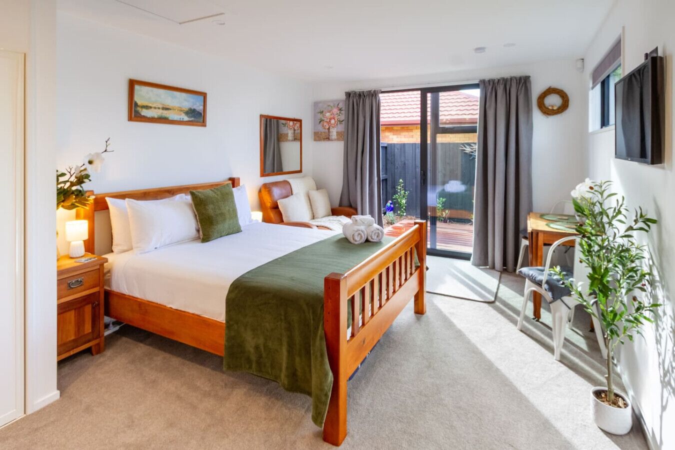 Hotelkamer met een bed, bureau, stoel, een kamerplant en uitzicht.