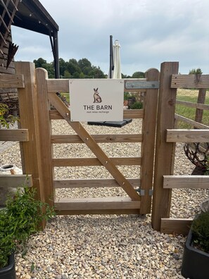 Una puerta de madera con un letrero que dice 'The Barn rest relax recharge'.