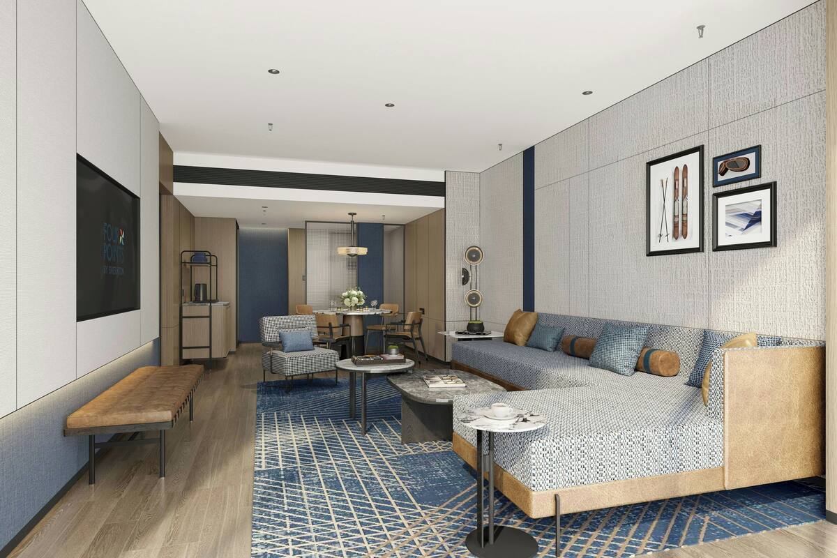 A modern living room with a sectional sofa, a dining area, and a kitchen in the background.