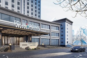 A modern hotel with a prominent sign reading "FOUR POINTS BESHERATOR".