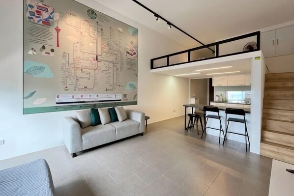 Een modern interieur met een grote kaart aan de muur, een bank en een keukenhoek.