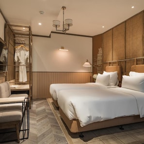 A modern bedroom with a large bed, bedside tables, a seating area, and a wardrobe.