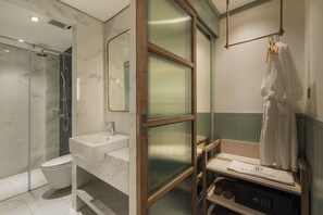 A bathroom with a glass-enclosed shower, a double sink, and a vanity with a mirror.