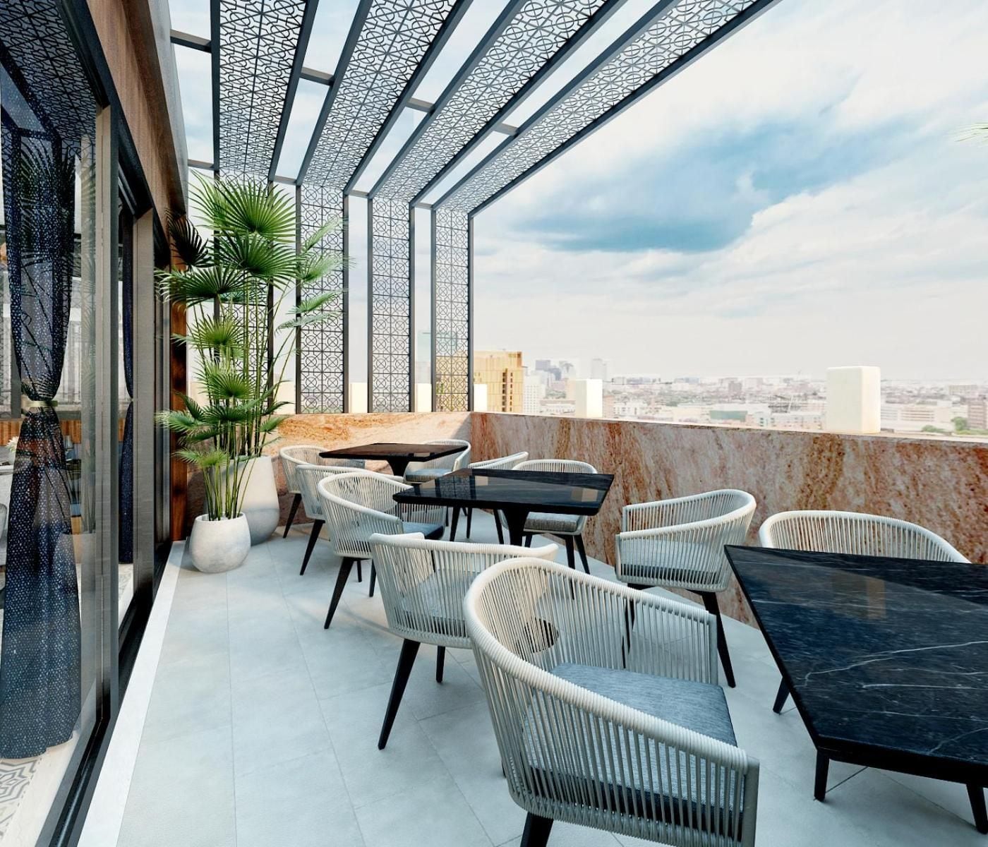 Een terras op het dak met buitenmeubilair, uitzicht over de stad en een decoratief metalen dak.
