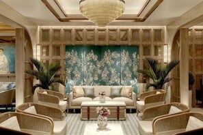 Un salon spacieux comprenant un canapé, des fauteuils, une table basse et un mur décoratif.